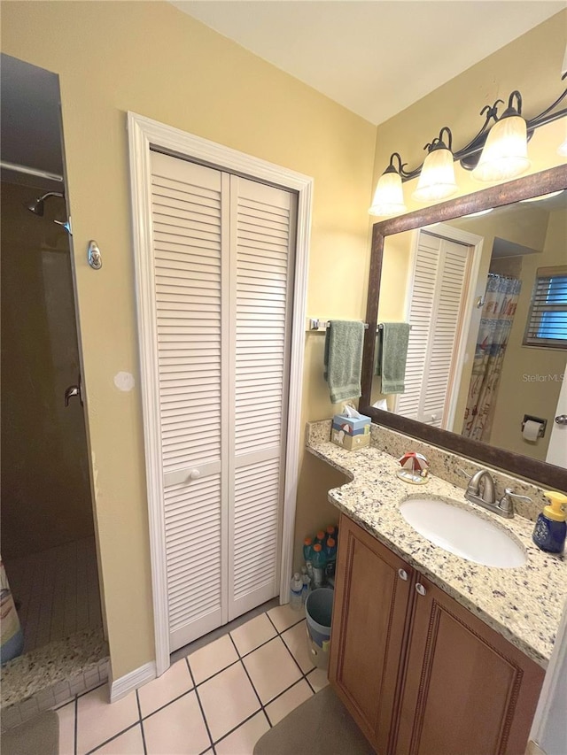 bathroom with tile patterned flooring, walk in shower, a closet, and vanity