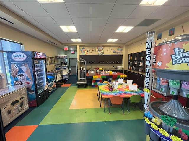 game room featuring finished concrete floors, a drop ceiling, and visible vents