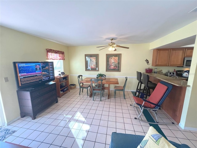 dining room with light tile patterned floors, baseboards, and a ceiling fan