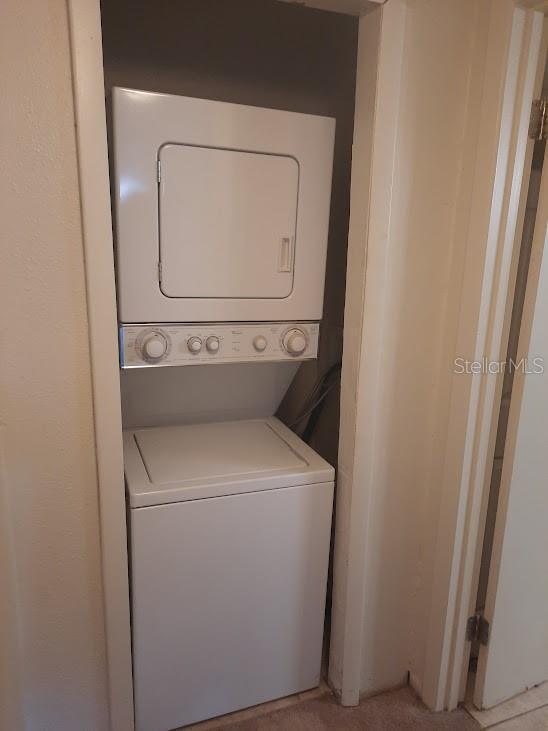 washroom featuring stacked washer / dryer