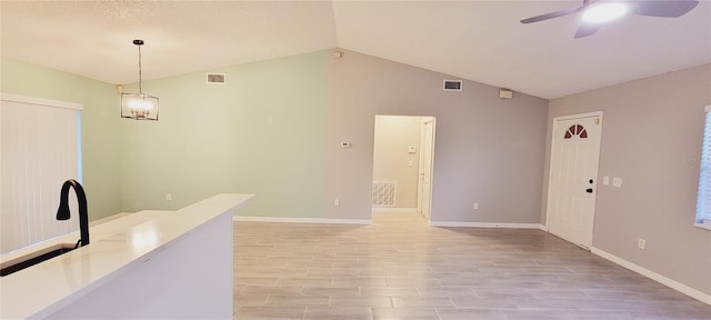 empty room with ceiling fan, lofted ceiling, and light wood-type flooring