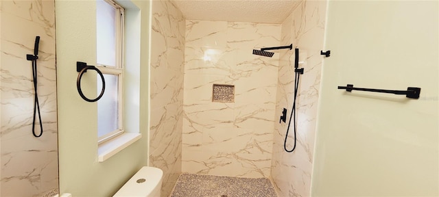 bathroom with a tile shower and a textured ceiling