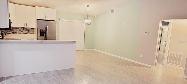 kitchen with white cabinetry, decorative light fixtures, light hardwood / wood-style floors, and stainless steel fridge with ice dispenser