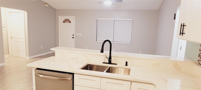 kitchen featuring white cabinetry, dishwasher, sink, and light stone counters