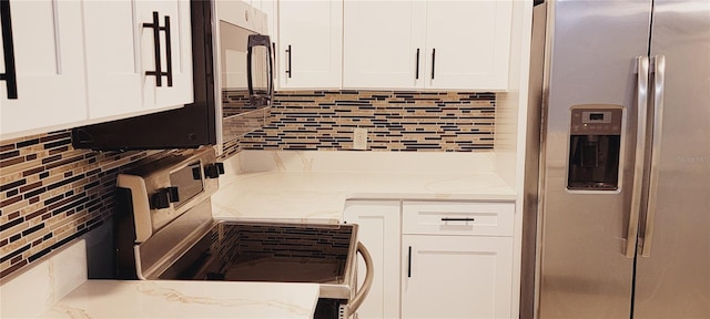 kitchen with light stone counters, stainless steel appliances, decorative backsplash, and white cabinets