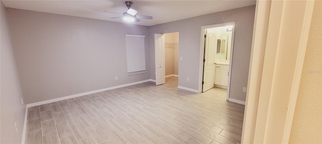 unfurnished bedroom with a walk in closet, ceiling fan, light hardwood / wood-style floors, ensuite bath, and a closet