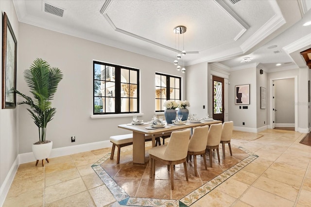 dining area with a raised ceiling, crown molding, and a textured ceiling