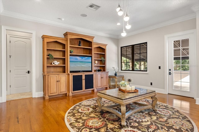 living room featuring ornamental molding, a textured ceiling, and light wood-type flooring