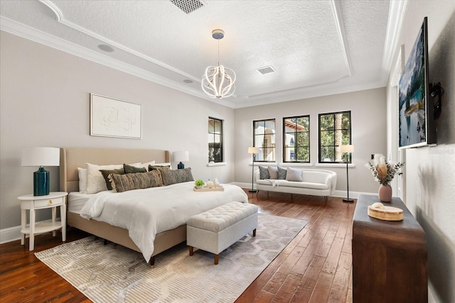 bedroom featuring wood-type flooring, crown molding, an inviting chandelier, and a textured ceiling