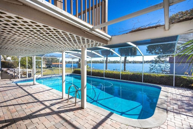 view of swimming pool featuring a patio, glass enclosure, and a water view