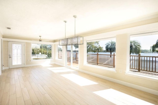 unfurnished sunroom featuring a water view