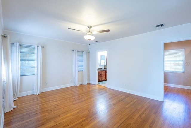 unfurnished room with hardwood / wood-style flooring, ornamental molding, and ceiling fan