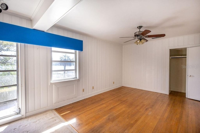 unfurnished bedroom with ceiling fan, ornamental molding, hardwood / wood-style floors, and multiple windows