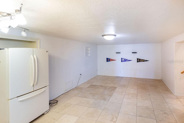 interior space with light tile patterned flooring and a textured ceiling