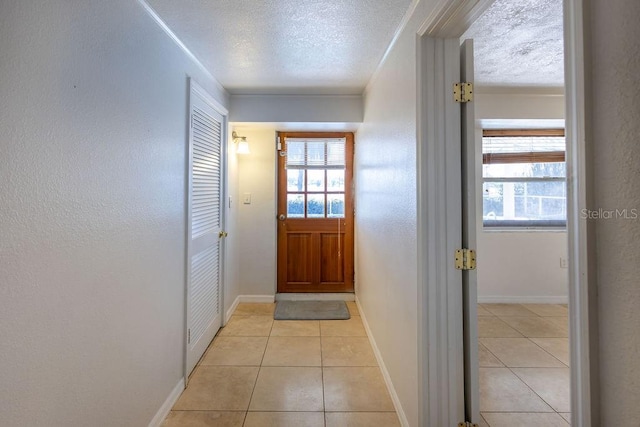 entryway with light tile patterned flooring and a textured ceiling