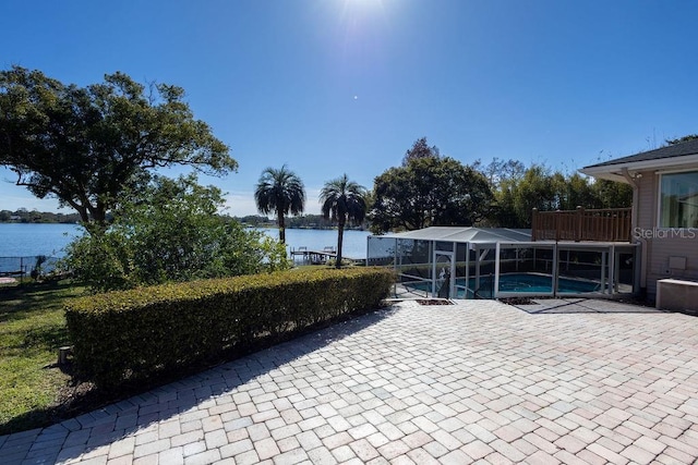 view of patio / terrace featuring glass enclosure and a water view