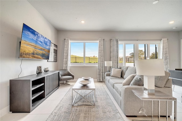 living room featuring a healthy amount of sunlight, a textured ceiling, and light tile patterned floors