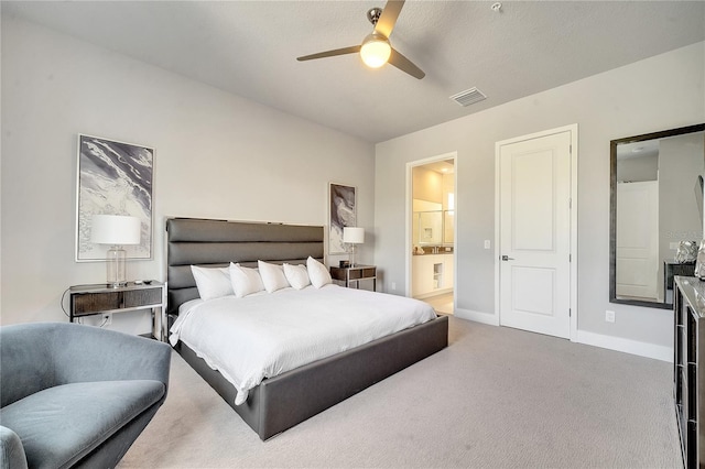 carpeted bedroom with ceiling fan and ensuite bath