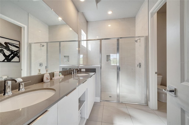 bathroom featuring tile patterned flooring, vanity, walk in shower, and toilet