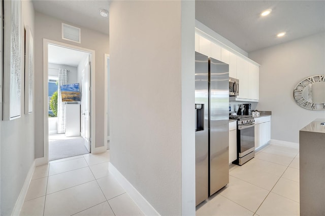 kitchen with white cabinetry, appliances with stainless steel finishes, and light tile patterned flooring