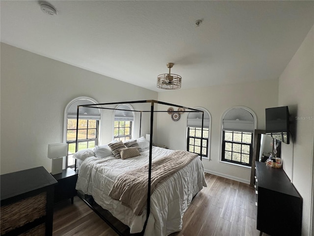 bedroom with lofted ceiling and dark hardwood / wood-style floors