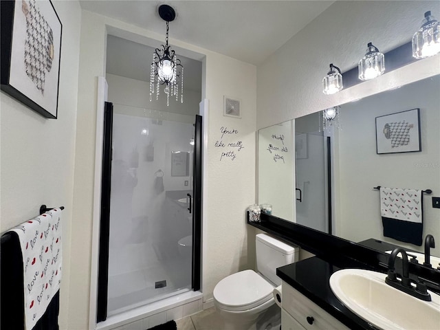 bathroom featuring vanity, a shower with door, and toilet