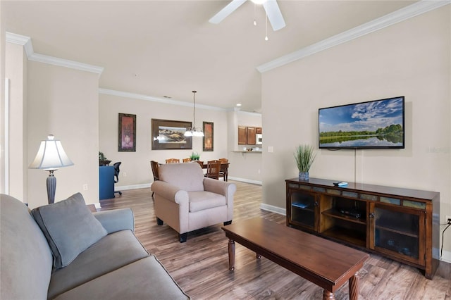 living room with hardwood / wood-style floors, ceiling fan with notable chandelier, and ornamental molding