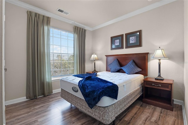 bedroom with ornamental molding and hardwood / wood-style floors