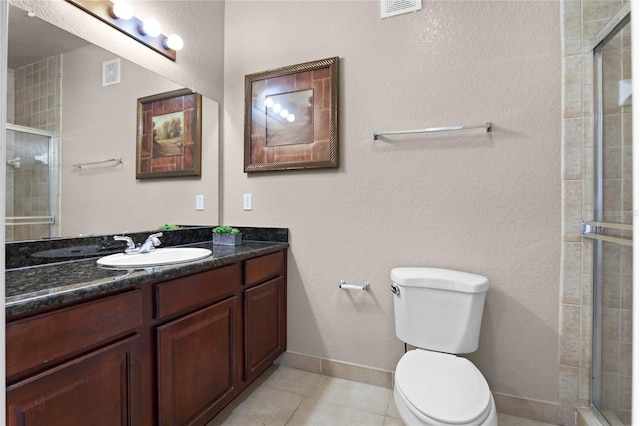 bathroom with vanity, tile patterned flooring, a shower with door, and toilet