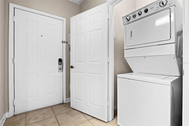 clothes washing area featuring stacked washer and dryer and light tile patterned floors