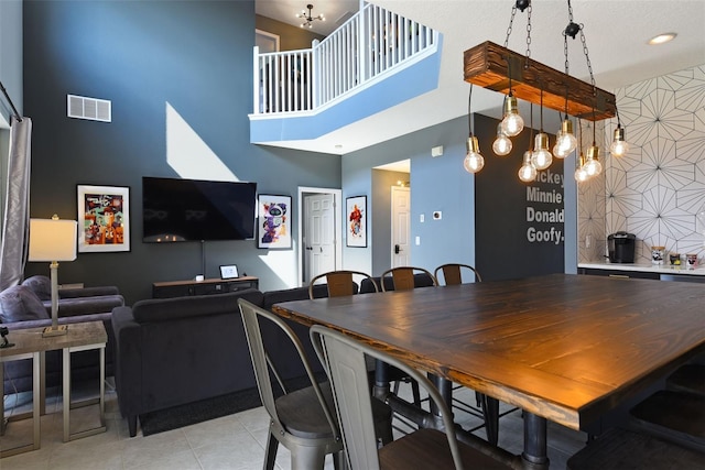 tiled dining room featuring a towering ceiling