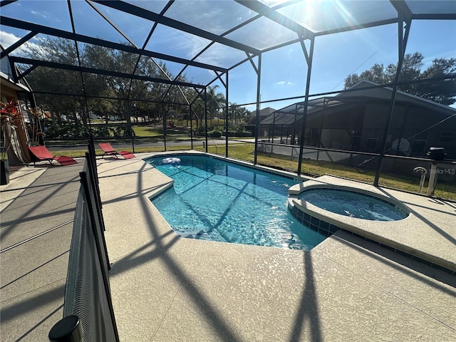 view of swimming pool with an in ground hot tub, glass enclosure, and a patio area