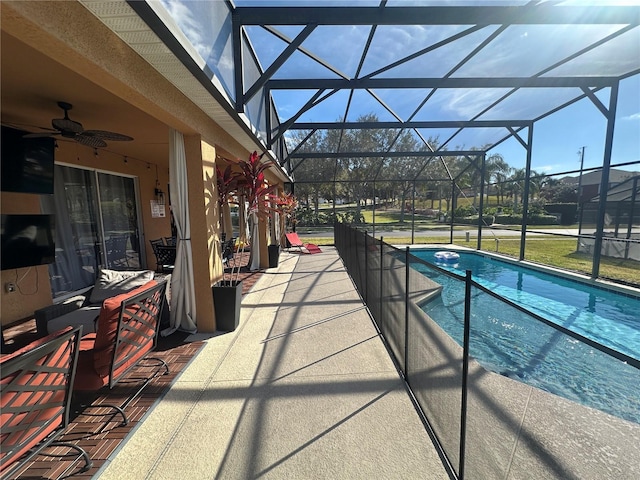 view of pool featuring ceiling fan, a patio, and glass enclosure