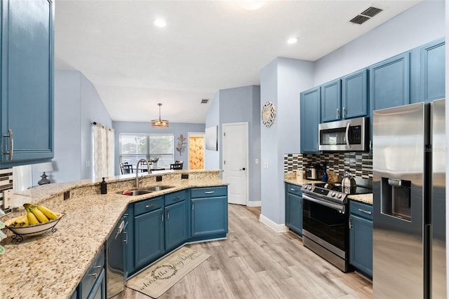 kitchen with sink, backsplash, hanging light fixtures, stainless steel appliances, and blue cabinetry