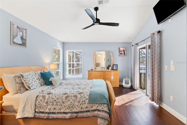 bedroom with wood-type flooring, vaulted ceiling, multiple windows, and access to outside