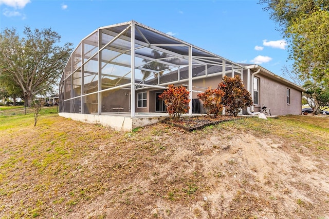 rear view of property with a lanai and a yard