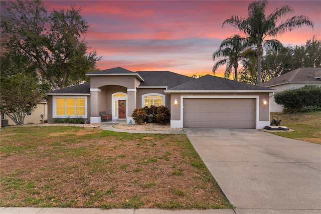 prairie-style home featuring a garage and a lawn