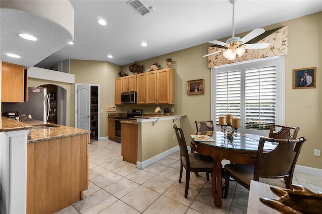 kitchen featuring light tile patterned floors, appliances with stainless steel finishes, kitchen peninsula, ceiling fan, and light stone countertops