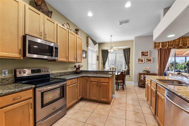 kitchen with a healthy amount of sunlight, appliances with stainless steel finishes, sink, and pendant lighting