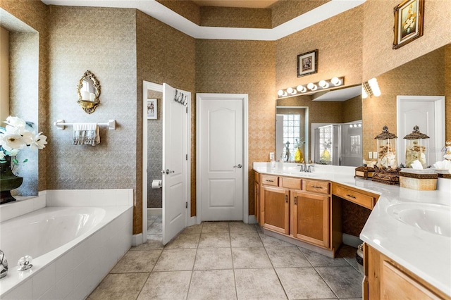 bathroom with tile patterned floors, vanity, and shower with separate bathtub