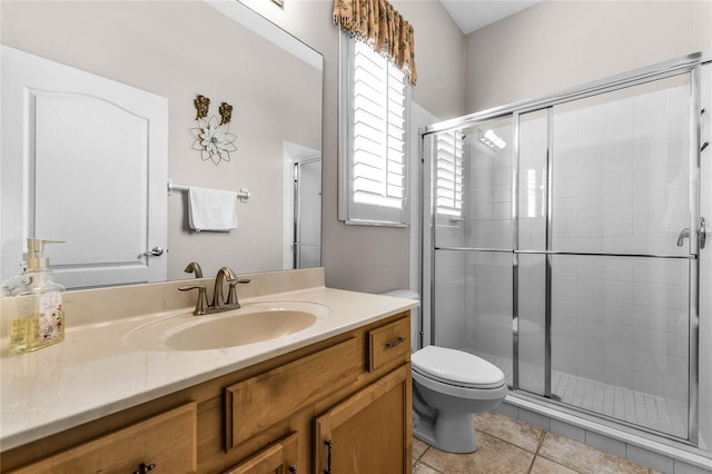 bathroom with tile patterned floors, vanity, toilet, and an enclosed shower