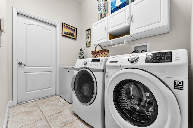 laundry area featuring cabinets, washer and dryer, and light tile patterned floors