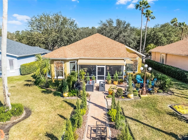 back of house with a yard and a sunroom