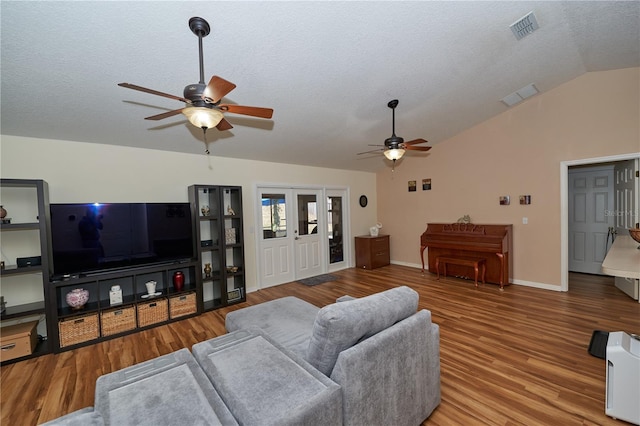 living room with lofted ceiling, hardwood / wood-style flooring, ceiling fan, a textured ceiling, and french doors