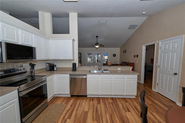 kitchen featuring stainless steel appliances, white cabinetry, sink, and kitchen peninsula