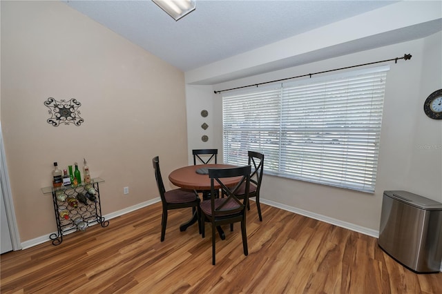 dining room featuring lofted ceiling and hardwood / wood-style floors