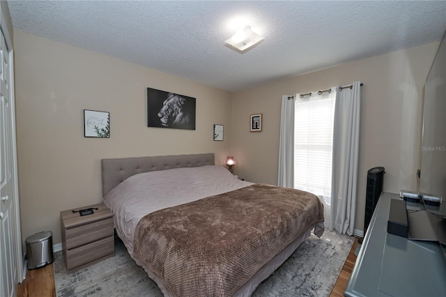 bedroom featuring a textured ceiling and light hardwood / wood-style floors