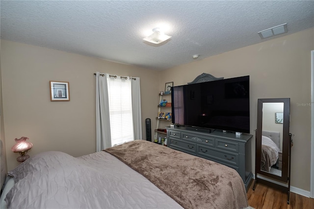 bedroom featuring wood-type flooring and a textured ceiling