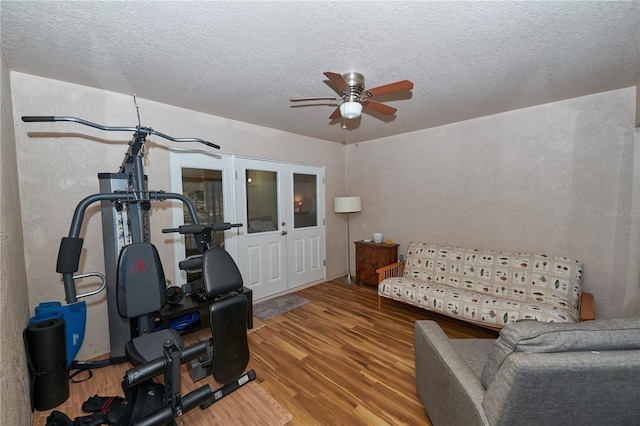 workout area with ceiling fan, hardwood / wood-style floors, and a textured ceiling