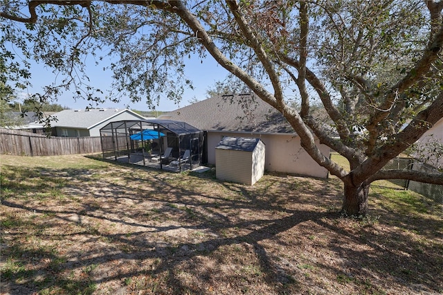 view of yard featuring glass enclosure and a storage shed